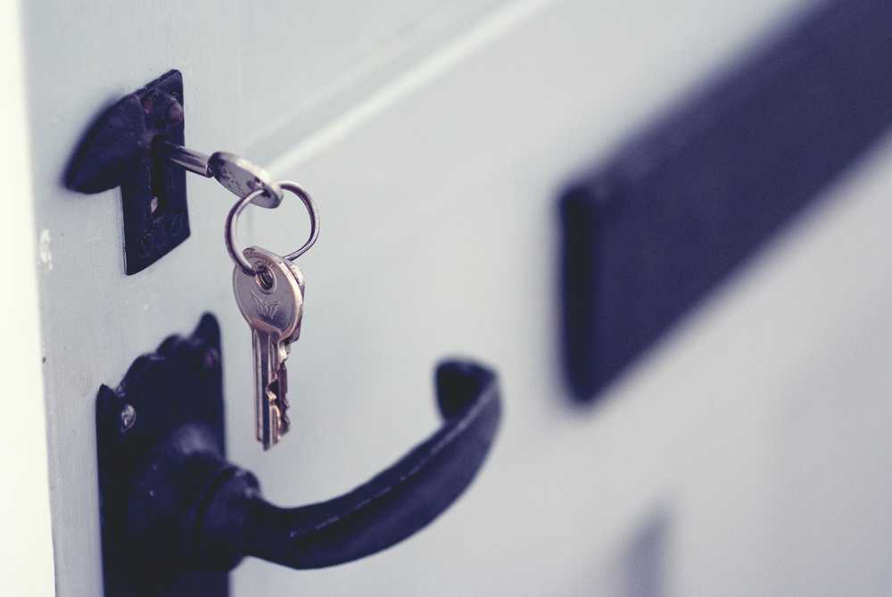 Black and silver padlock on white door