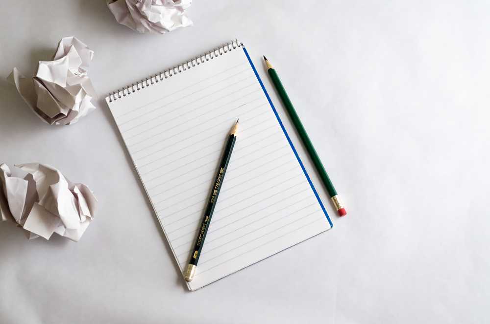 Discarded paper sheets next to a notebook